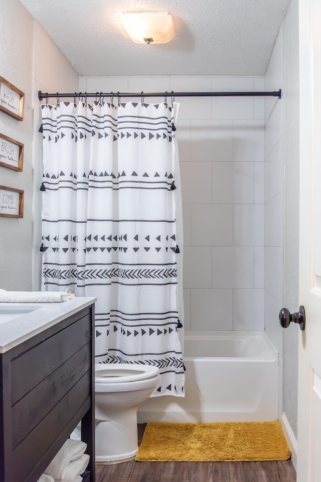 full bathroom with vanity, shower / tub combo, a textured ceiling, and toilet