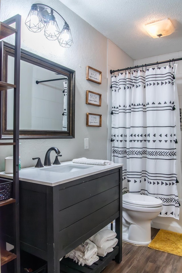 bathroom featuring toilet, a shower with curtain, a textured ceiling, vanity, and hardwood / wood-style flooring