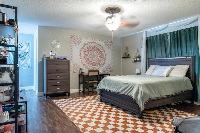 bedroom with dark hardwood / wood-style flooring, ceiling fan, and a textured ceiling