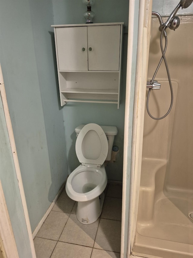 bathroom featuring tile patterned flooring, a shower, and toilet