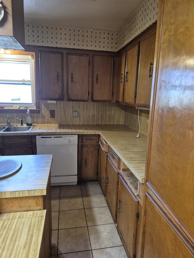 kitchen with sink, light tile patterned floors, and white dishwasher