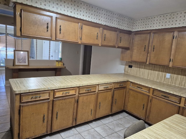 kitchen with light tile patterned flooring and kitchen peninsula