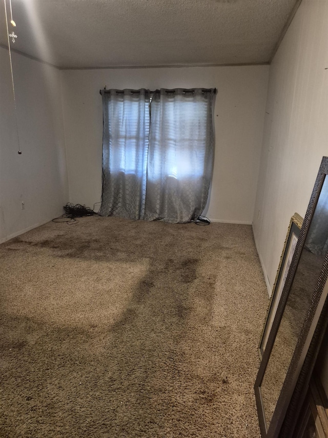 carpeted empty room with a textured ceiling