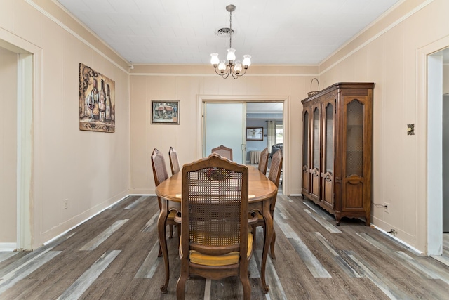 4300 Ferndale Dr, Port Arthur, TX 77642 - dining room with crown molding, dark wood-style flooring, a chandelier, and a decorative wall