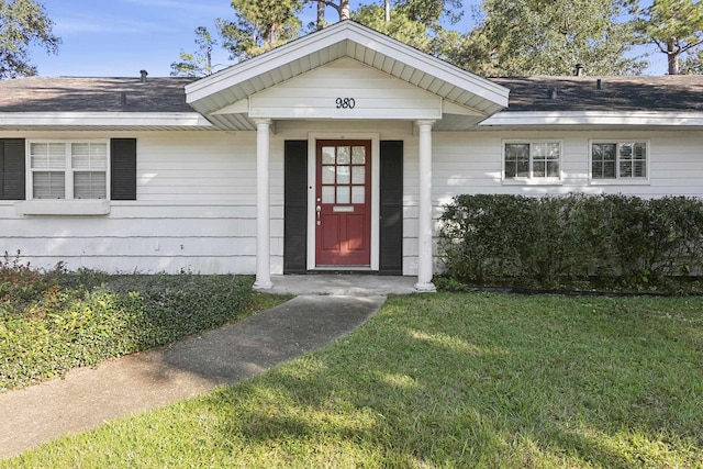 doorway to property with a yard