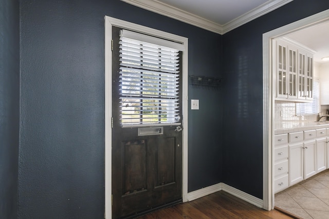 entryway with ornamental molding, sink, and wood-type flooring