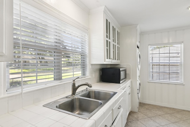 kitchen featuring white cabinetry, sink, light tile patterned floors, and tile countertops