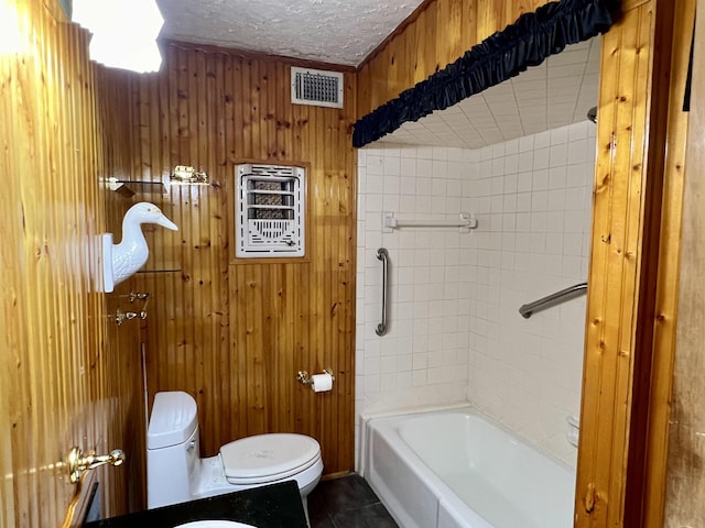 bathroom featuring tile patterned floors, a textured ceiling, toilet, and wood walls