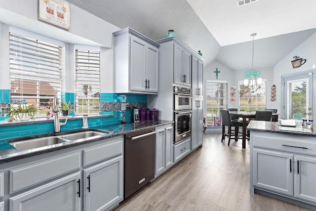 200 Skylark Ave, Bridge City, TX 77611 - kitchen with appliances with stainless steel finishes, gray cabinetry, lofted ceiling, a chandelier, and light wood finished floors