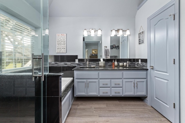 200 Skylark Ave, Bridge City, TX 77611 - full bathroom with double vanity, wood finished floors, a bath, and a shower with door