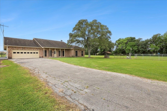 7385 Fannett Rd, Beaumont, TX 77705 - ranch-style house with an attached garage, asphalt driveway, brick siding, and a shingled roof