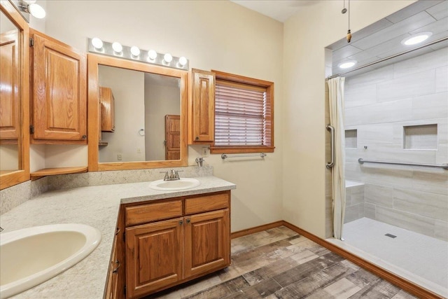 7385 Fannett Rd, Beaumont, TX 77705 - bathroom with tiled shower, double vanity, and wood finished floors