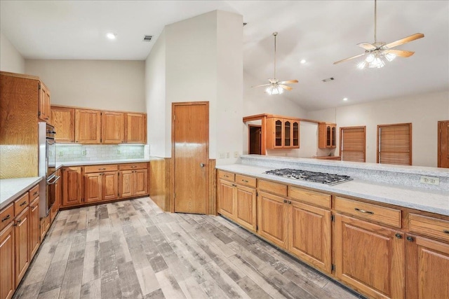 7385 Fannett Rd, Beaumont, TX 77705 - kitchen with high vaulted ceiling, appliances with stainless steel finishes, light wood-style flooring, a ceiling fan, and tasteful backsplash