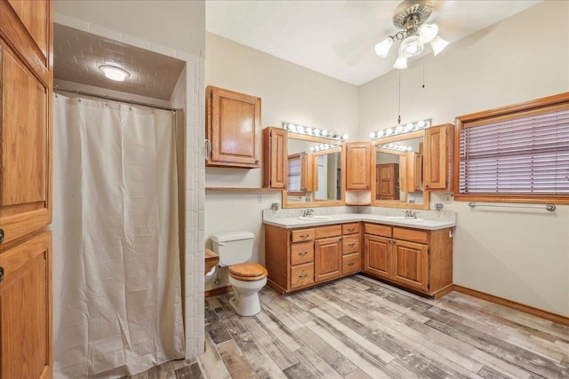 7385 Fannett Rd, Beaumont, TX 77705 - full bath featuring a ceiling fan, wood finished floors, toilet, double vanity, and baseboards