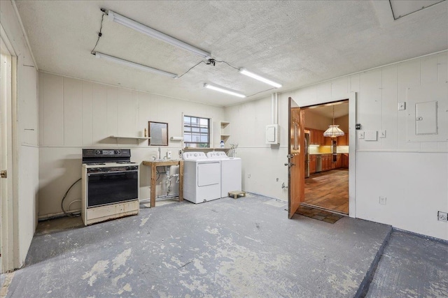 7385 Fannett Rd, Beaumont, TX 77705 - kitchen with gas range gas stove, washer and clothes dryer, open shelves, and a textured ceiling
