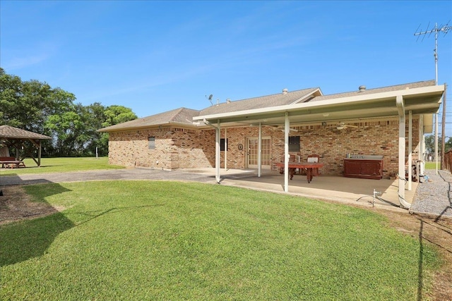 7385 Fannett Rd, Beaumont, TX 77705 - rear view of house featuring a patio area, a gazebo, brick siding, and a lawn