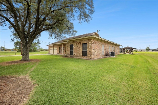 7385 Fannett Rd, Beaumont, TX 77705 - view of side of property with brick siding, a garage, a lawn, a gazebo, and central AC