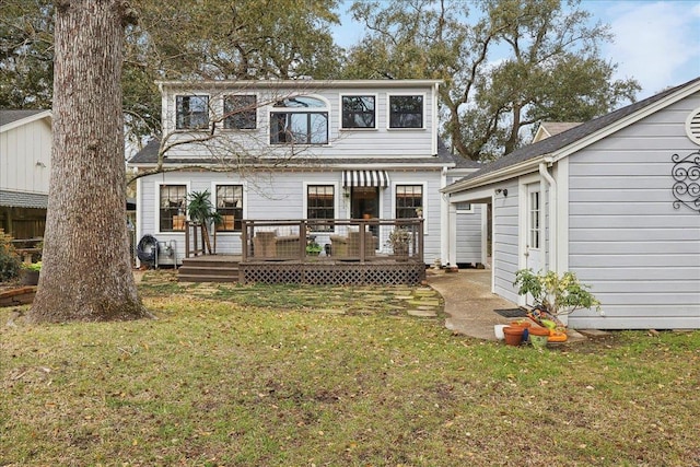 rear view of property with a lawn and a wooden deck