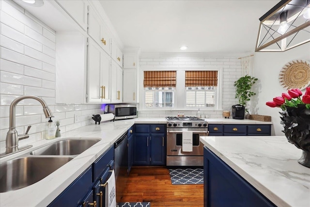 kitchen featuring blue cabinets, stainless steel appliances, tasteful backsplash, and a sink