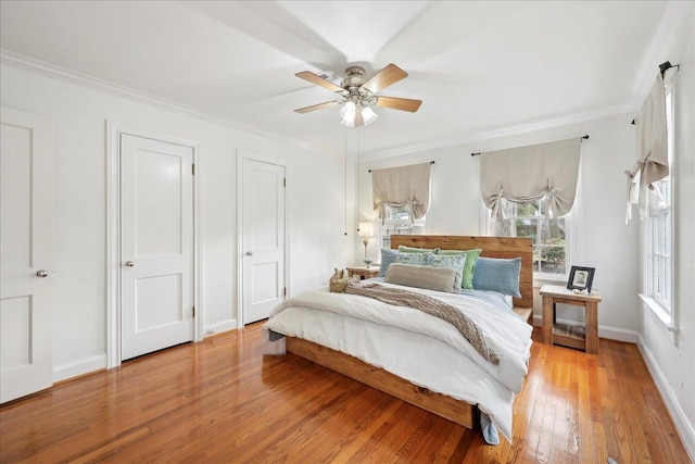 bedroom featuring a ceiling fan, baseboards, light wood-style floors, and crown molding