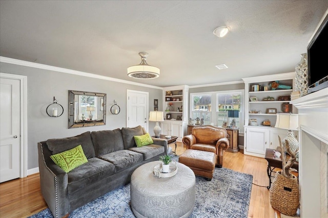 living room featuring a textured ceiling, ornamental molding, and light wood finished floors