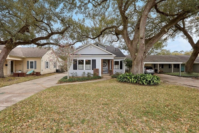 view of front of house with concrete driveway, a carport, and a front yard