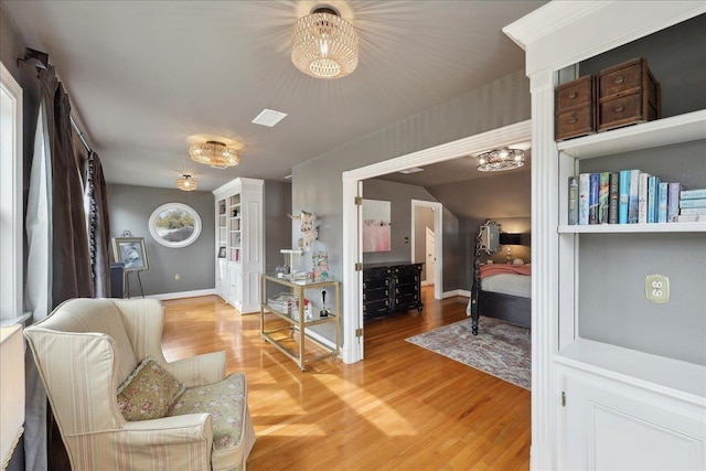 sitting room with visible vents, baseboards, and light wood-style floors