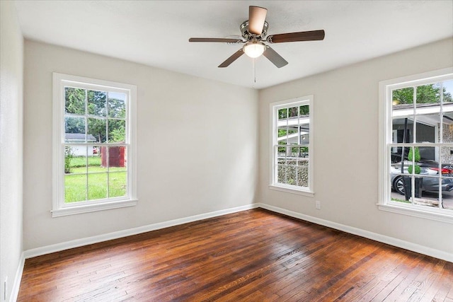 spare room featuring ceiling fan, a healthy amount of sunlight, and dark hardwood / wood-style flooring