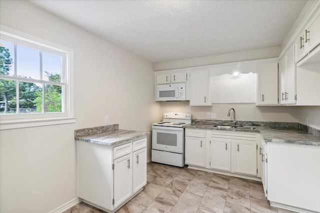 kitchen featuring white cabinets, a textured ceiling, white appliances, and sink