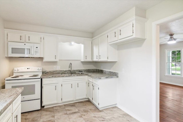 kitchen featuring white cabinetry, sink, ceiling fan, a textured ceiling, and white appliances