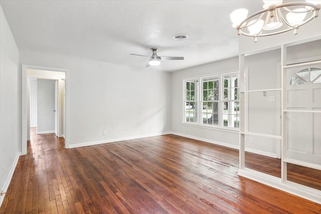 unfurnished living room featuring a textured ceiling, dark wood-type flooring, and ceiling fan with notable chandelier