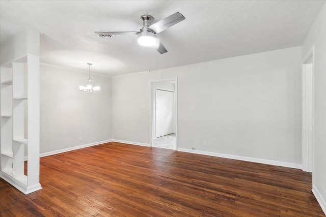 empty room featuring ceiling fan with notable chandelier, a textured ceiling, and dark wood-type flooring