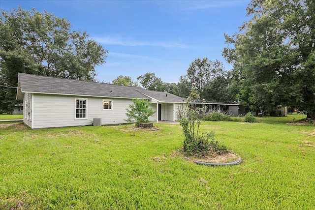 back of house with a yard and central AC unit