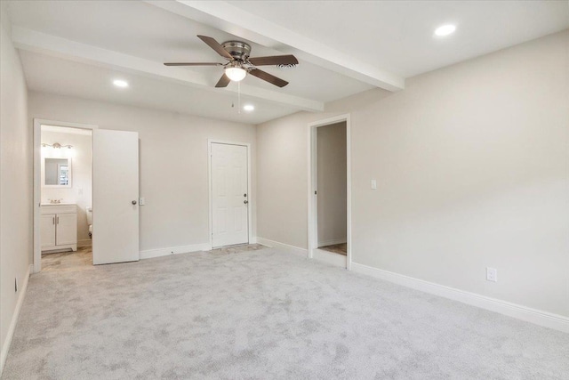 unfurnished bedroom with connected bathroom, ceiling fan, beamed ceiling, and light colored carpet