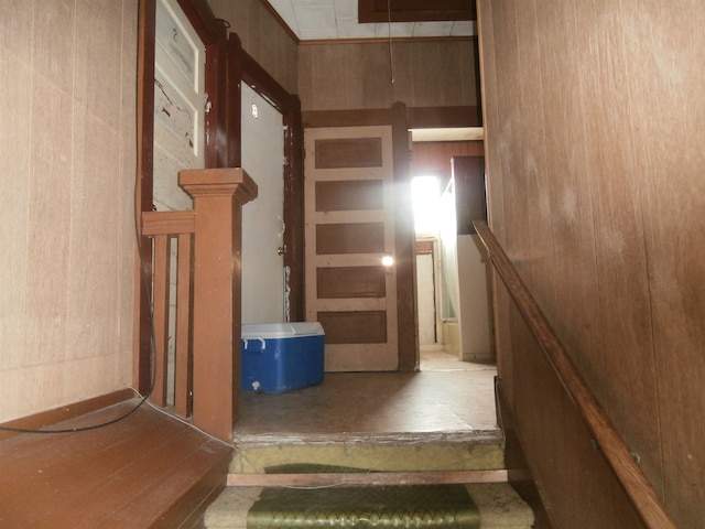 stairs featuring wood walls