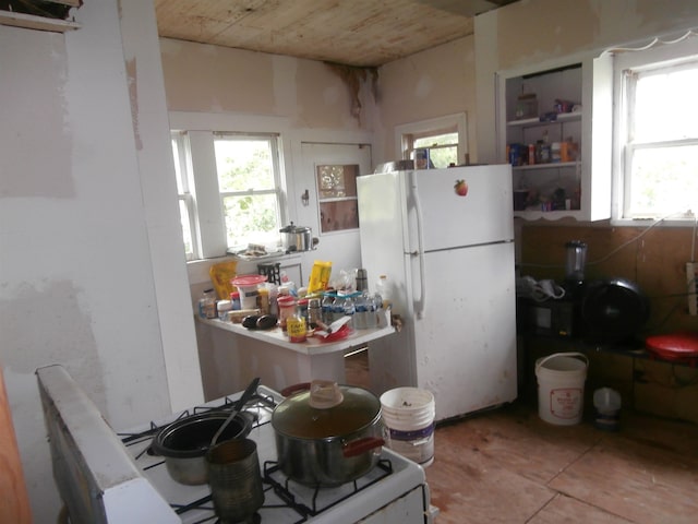 kitchen featuring tile patterned flooring, stove, and white refrigerator