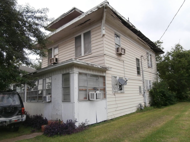 view of property exterior featuring a lawn and cooling unit