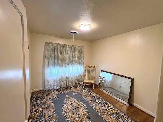 unfurnished room with dark wood-type flooring and a textured ceiling