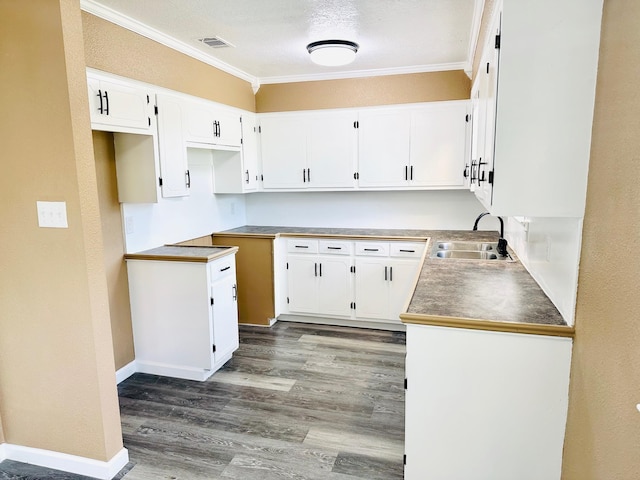 9130 Doty St, Beaumont, TX 77707 - kitchen with a sink, ornamental molding, wood finished floors, white cabinets, and baseboards