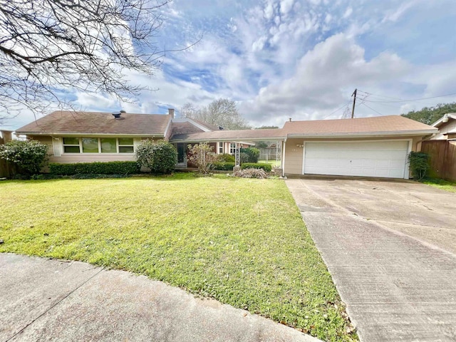 ranch-style house featuring an attached garage, driveway, a front yard, and fence