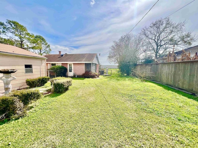 view of yard with fence and central AC unit