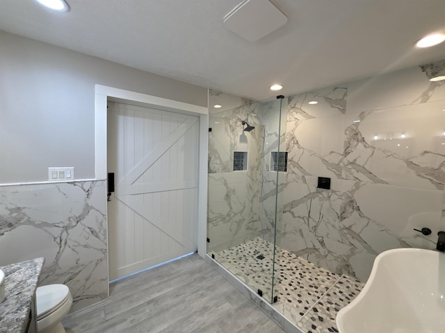 full bathroom featuring wood-type flooring, shower with separate bathtub, sink, tile walls, and toilet