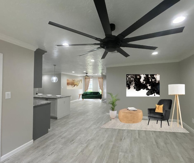 living area with ceiling fan, crown molding, and light wood-type flooring