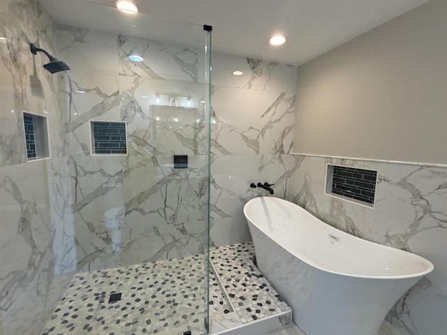 bathroom featuring independent shower and bath and tile walls