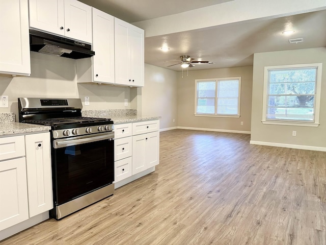 kitchen with stainless steel range, white cabinetry, and light stone countertops