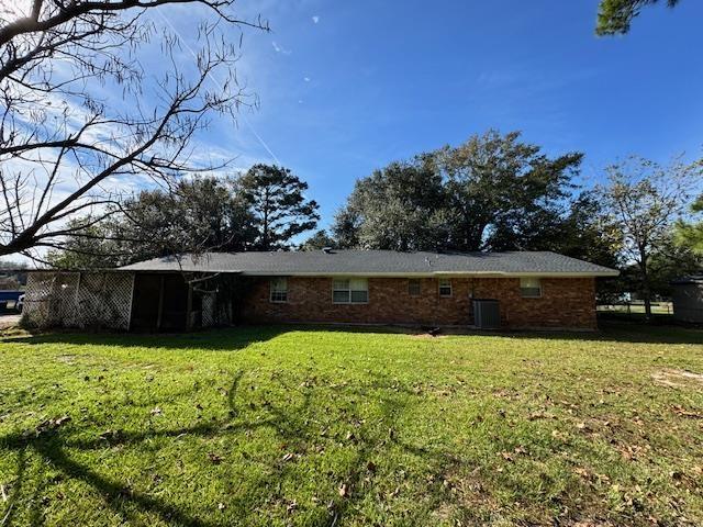 rear view of house featuring a lawn