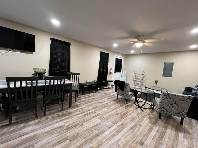 interior space featuring electric panel, ceiling fan, and light wood-type flooring