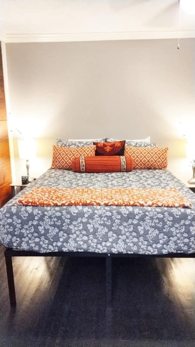 bedroom with wood-type flooring and ornamental molding