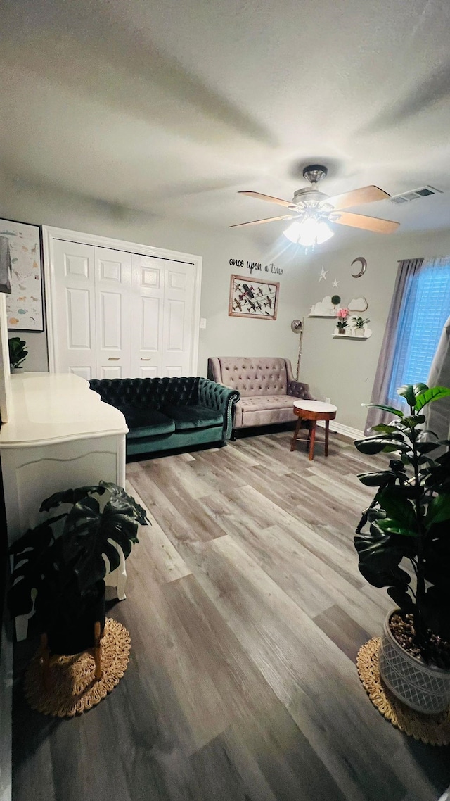 living room with ceiling fan and light hardwood / wood-style flooring