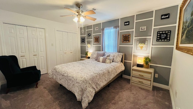 carpeted bedroom with ceiling fan and two closets